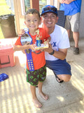 Parent and child posing with small trophy and 28" Mini Baseball Championship Belt