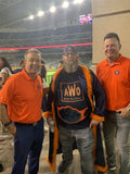 Three men are pictured while one is wearing a Baseball Championship Belt